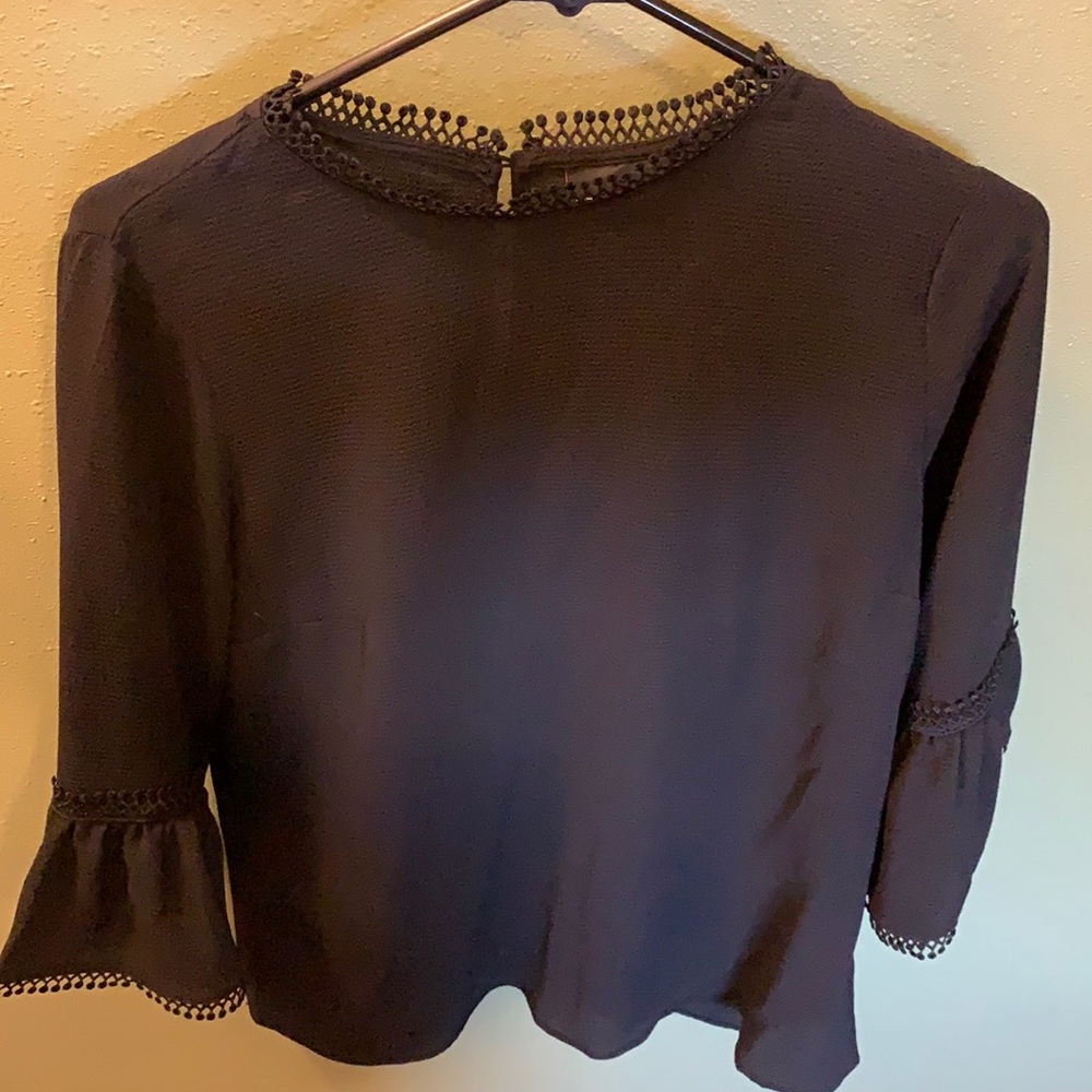Flowing black blouse, with quarter bell sleeves.